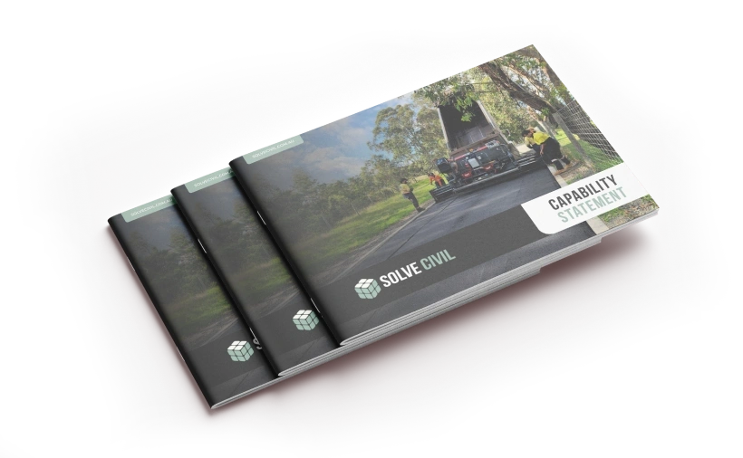 A stack of brochures titled "Capability Statement" with a cover image of a road and truck surrounded by trees. The logo reads "Solve Civil" in green and white.